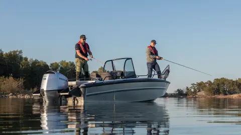 Due uomini che pescano da una barca in una posizione sul lago. 