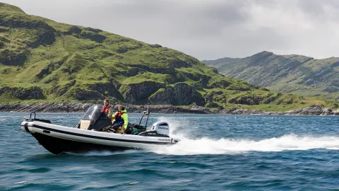 Due signori su una barca con motori Honda in un luogo sul lago. 