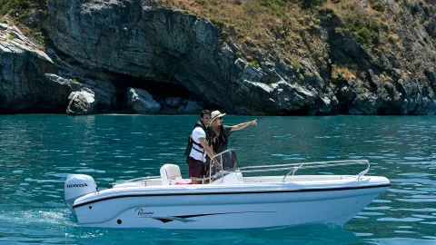 Coppia su una piccola barca in un lago con motore Honda BF.