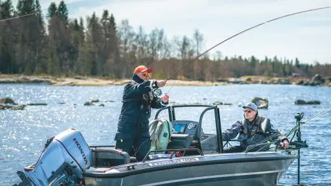 Uomini che pescano da una barca con motore Honda BF30 in un lago.