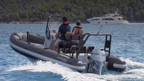 Coppia su una barca Highfield rivolta verso poppa dotata di motore BF50 in posizione oceanica