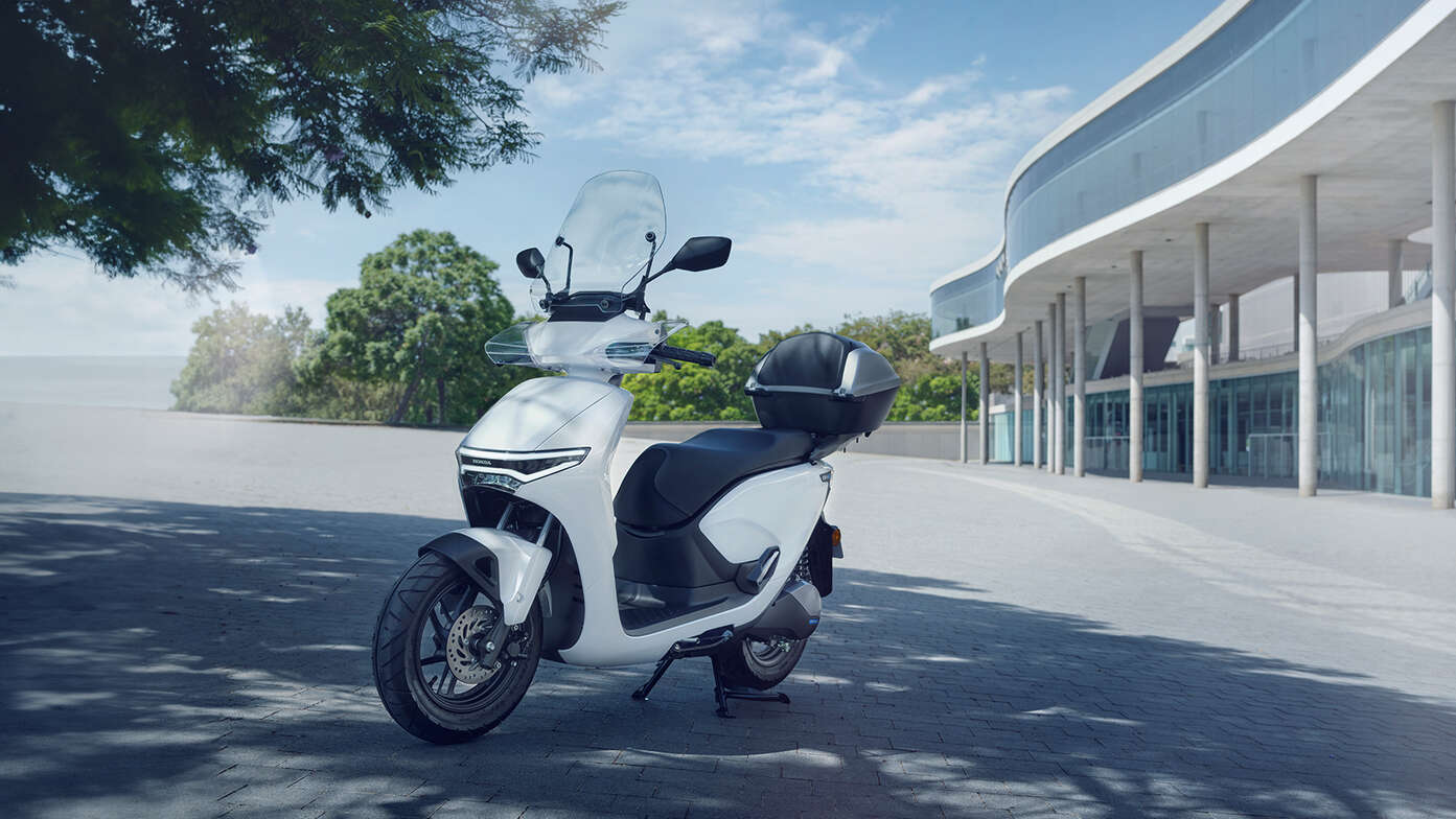 Scooter elettrico Honda CUV e: parcheggiato in città che mostra lo schermo.